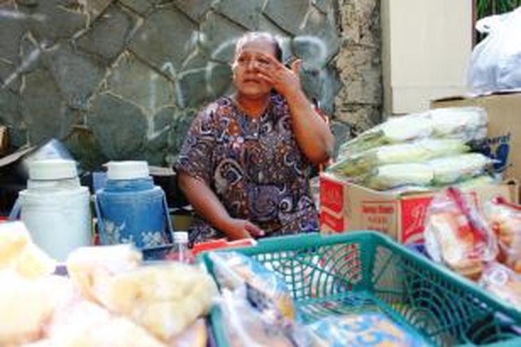 Sri Nani (52), melamun dan meratapi minuman dan makanan ringan barang dagangannya di atas meja darurat, pinggiran jalan, setelah ditertibkan oleh PT KAI Daop III Cirebon, Kamis (25/9/2104). Lapak Sri adalah satu dari 76 lapak PKL yang berdagang di jalan prujakan, Kota Cirebon, yang ditertibkan PT KAI.