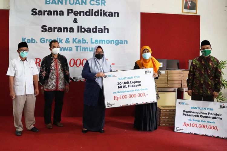 General Manager of CSR SIG Edy Saraya (dua dari kiri) bersama Wakil Bupati Gresik Aminatun Habibah (tengah), saat menyerahkan bantuan secara simbolis.