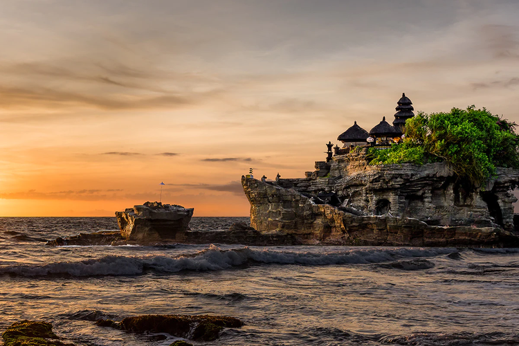 Pemandangan Pura Tanah Lot saat matahari terbenam.