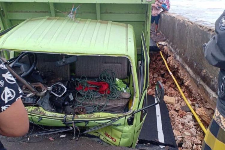 Sebuah truk angkutan besi, terperosok setelah jalan yang mengubungkan antara Kabupaten Sampang dan Pamekasan di Desa Tamberu, Kecamatan Batumarmar, amblas karena abrasi, Senin (26/12/2022).