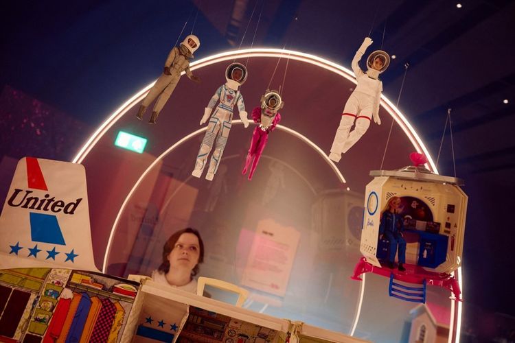 Seorang asisten galeri melihat boneka Barbie yang dibawa ke luar angkasa oleh astronot Badan Antariksa Eropa (ESA) dan komandan perempuan pertama Eropa di Stasiun Luar Angkasa Internasional Samantha Cristoforetti (kanan atas) selama sesi pemotretan Barbie: The Exhibition di The Design Museum di London pada 1 Juli 2024.