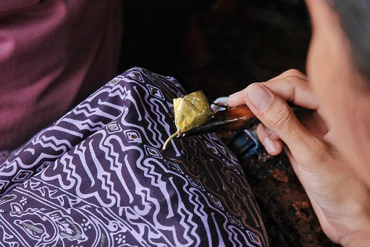 A craftswoman makes batik tulis (written batik), the oldest form of batik