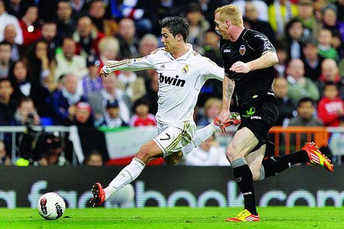 Bintang Real Madrid asal Portugal, Cristiano Ronaldo (kiri), coba menendang bola di tengah kawalan pemain  Valencia, Jeremy Mathieu, dalam pertandingan Liga Spanyol di Santiago Bernabeu, Minggu (8/4) malam waktu setempat. Skor akhir 0-0.