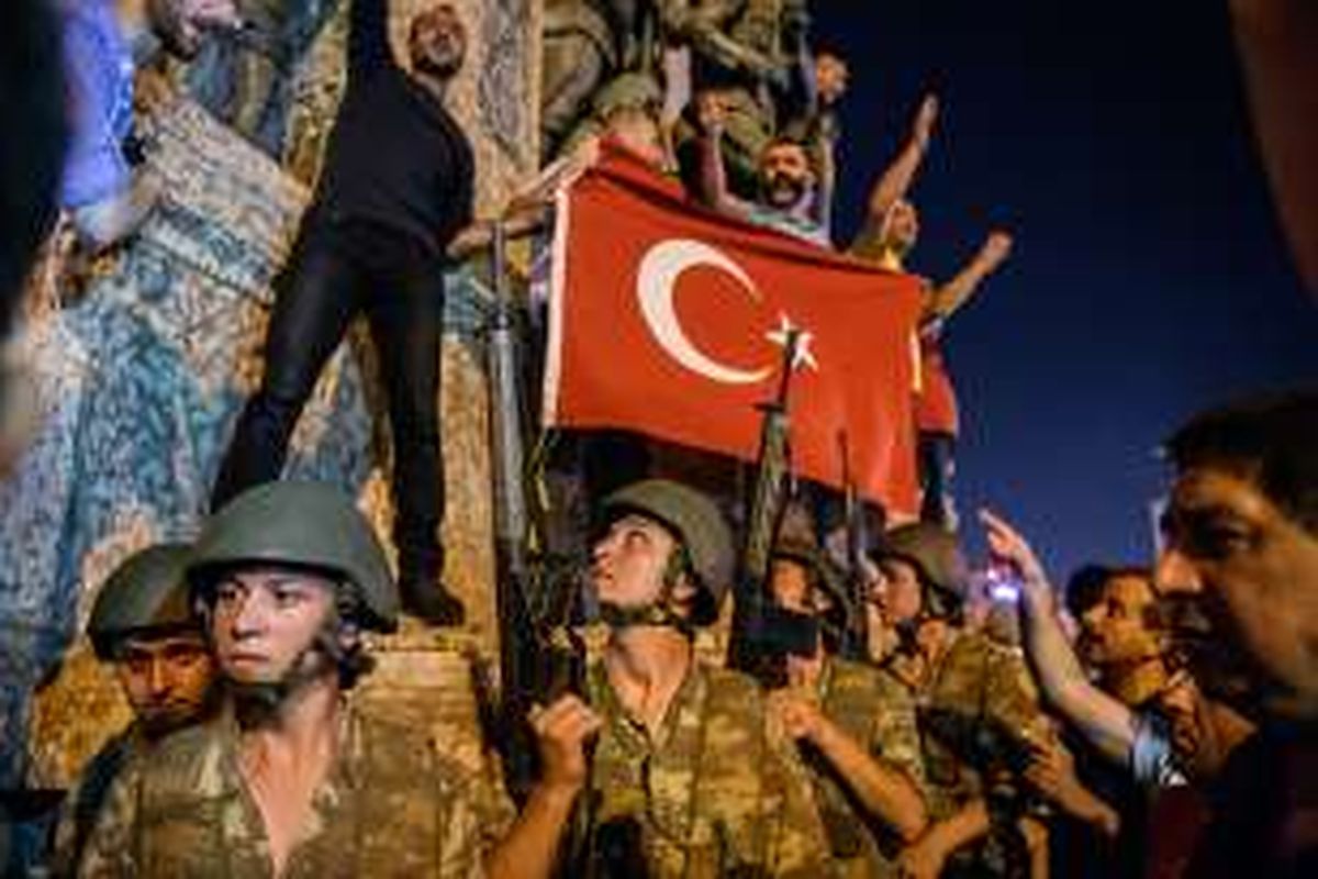 Tentara Turki berjaga dengan senjata di Taksim Square, saat sejumlah orang memprotes melawan kudeta militer di Istanbul, Sabtu (16/7/2016) waktu setempat. Upaya kudeta terjadi pada Jumat malam setelah militer mengeluarkan pernyataan telah mengambil alih kekuasaan untuk mengembalikan aturan dan demokrasi di negeri itu.