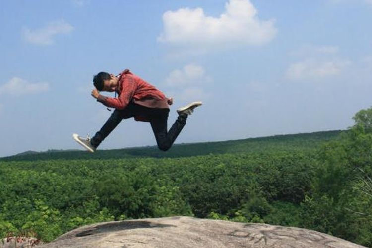 Wisatawan tengah berpose melompat di atas Taman Batu Granit Indah di Tanjung Bintang, Kabupaten Lampung Selatan.