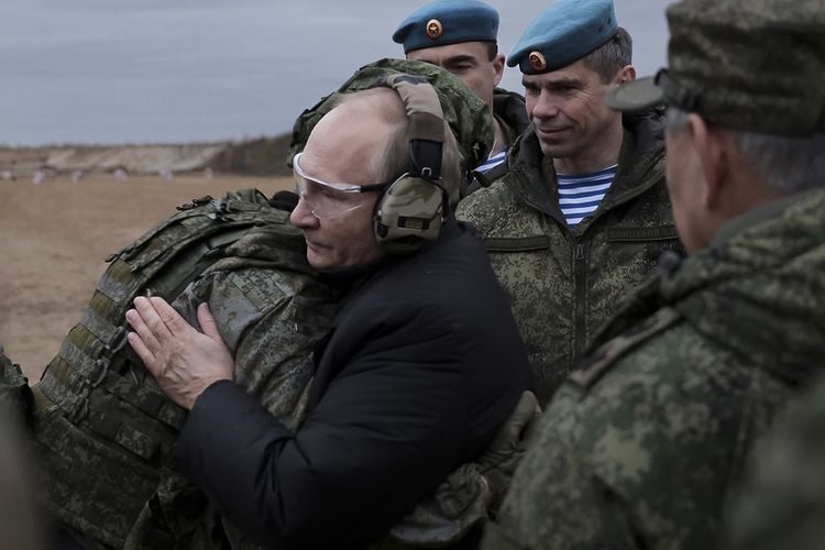 Presiden Rusia Vladimir Putin memeluk seorang tentara saat mengunjungi pusat pelatihan mobilisasi parsial di Ryazan, Rusia, Kamis (20/10/2022), dalam lanjutan perang Rusia-Ukraina terkini.