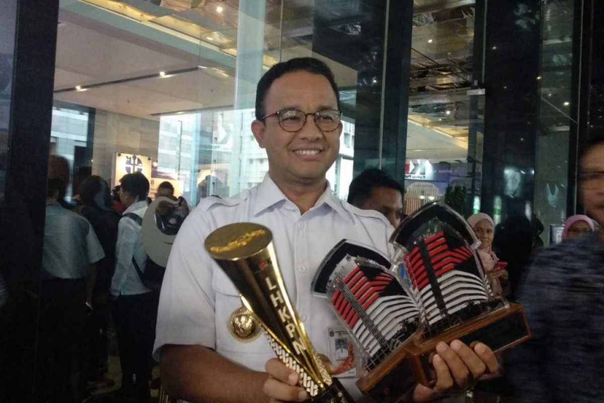 Gubernur DKI Jakarta Anies Baswedan menunjukkan piagam penghargaan yang diterima Pemprov DKI dari Komisi Pemberantasan Korupsi (KPK) di Hari Antikorupsi Sedunia (Hakordia) 2018 yang digelar di Hotel Bidakara, Jakarta Selatan, Rabu (5/12/2018)