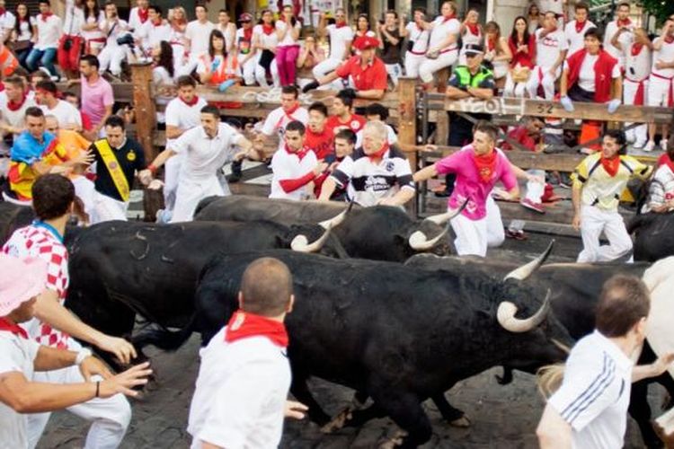 Festival Saint Fermin di Pamplona, Spanyol. Di festival ini, peserta dikejar banteng yang berlari di antara jalanan kota Pamplona.