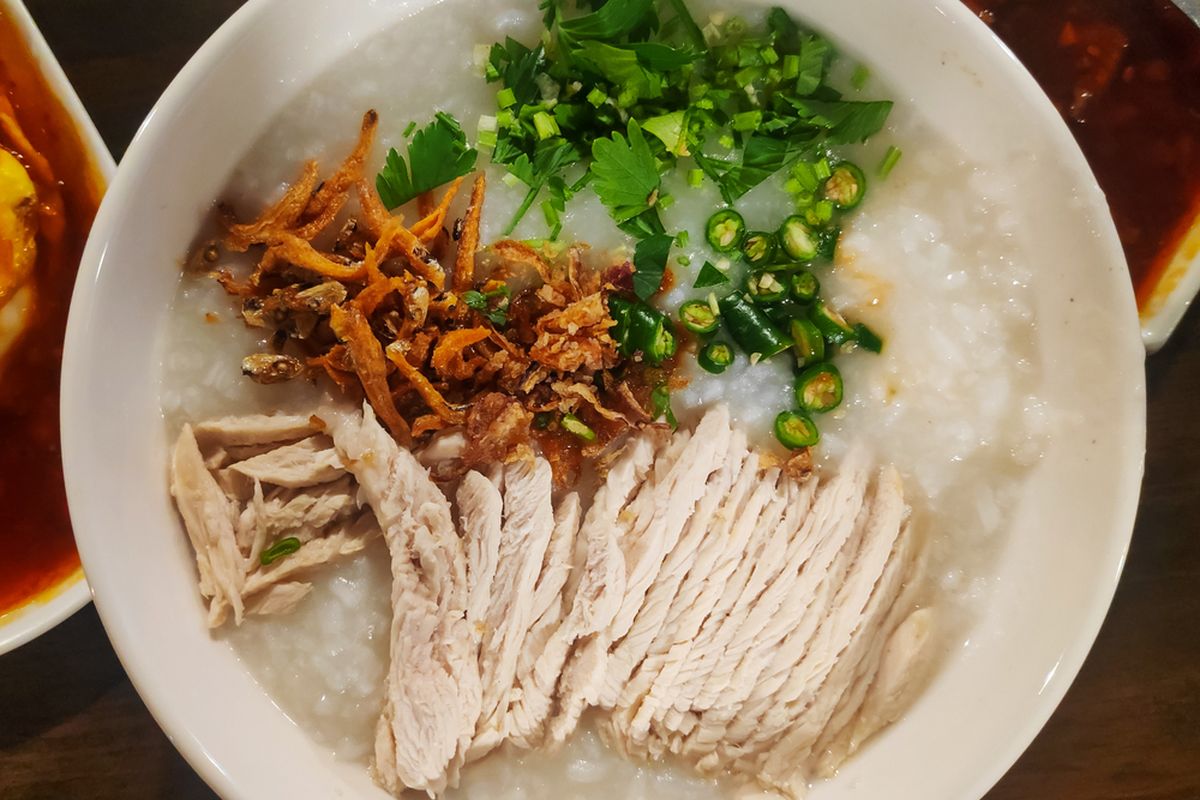 Ilustrasi bubur nasi dengan topping suwiran ayam, bawang goreng, irisan seledri, dan cabai.
