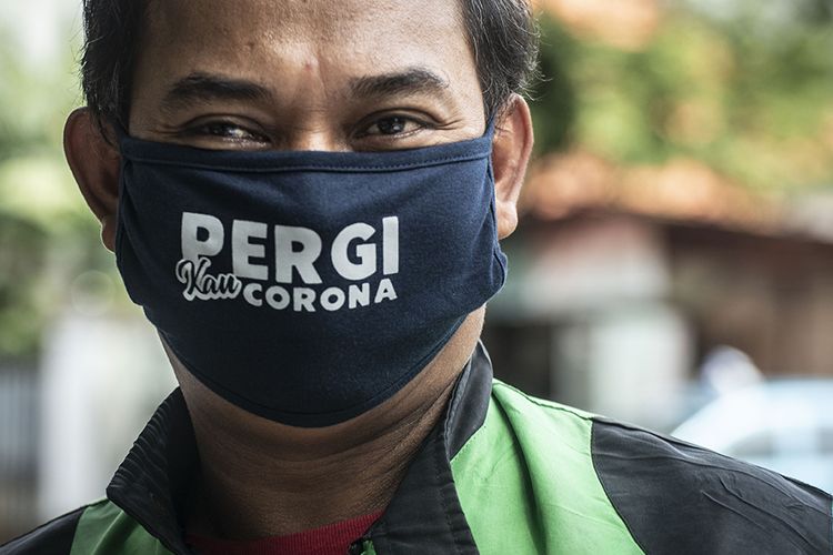 Pengemudi ojek daring menggunakan masker saat pembagian makanan gratis di kawasan Menteng, Jakarta, Jumat (3/4/2020). Pembagian makanan gratis tersebut merupakan sebagai bentuk kepedulian terhadap sesama di tengah-tengah pandemi COVID-19.