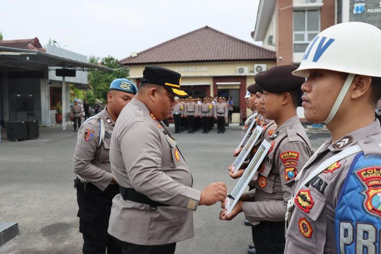 Kapolres Pamekasan, AKBP Jazuli Dani Iriawan, saat menandatangani foto 3 anggota polisi dalam figura yang diberhentikan dengan tidak hormat karena melakukan pelanggaran hukum dan pelanggaran etika profesi anggota Polri, Senin (15/1/2024).