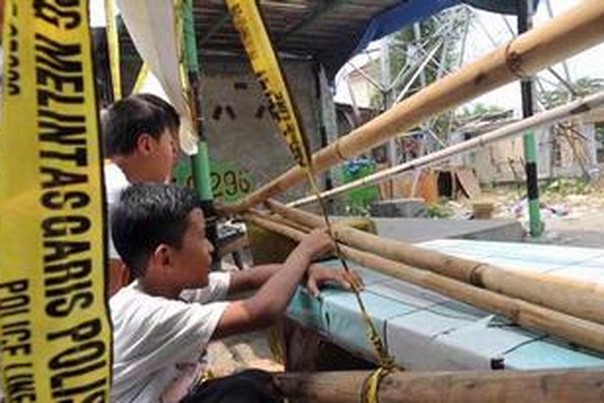 Warga bergerombolan melihat lokasi rumah kontrakan yang rusak akibat bom rakitan di Jalan Nusantara, Kelurahan Beji, Kota Depok, Minggu (9/9/2012). Pasca ledakan yang mengakibatkan tiga korban luka tersebut, polisi menutup dan menyisir lokasi untuk mencari bahan peledak dan bukti-bukti lain guna kepentingan penyelidikan.  