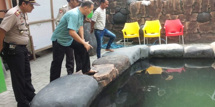 Masudin (baju biru), pemilik ikan Arapaima di Jombang, Jawa Timur, ketika menerima polisi yang datang mengecek.