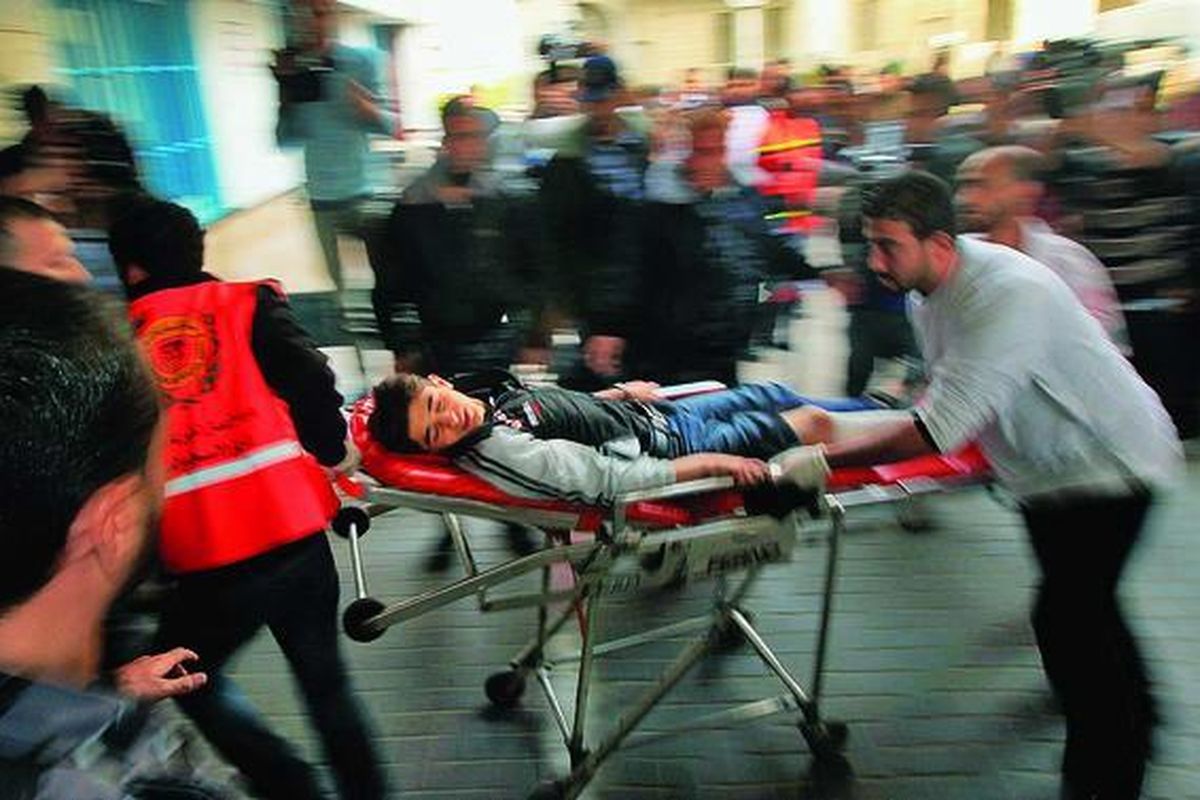 Petugas medis Palestina menolong seorang anak yang terluka di Rumah Sakit Al-Shifa, Gaza City, Jumat (16/11). Militan Gaza menembakkan roket dengan sasaran Tel Aviv dan mengabaikan peringatan Israel yang akan membalas dengan serangan darat.  