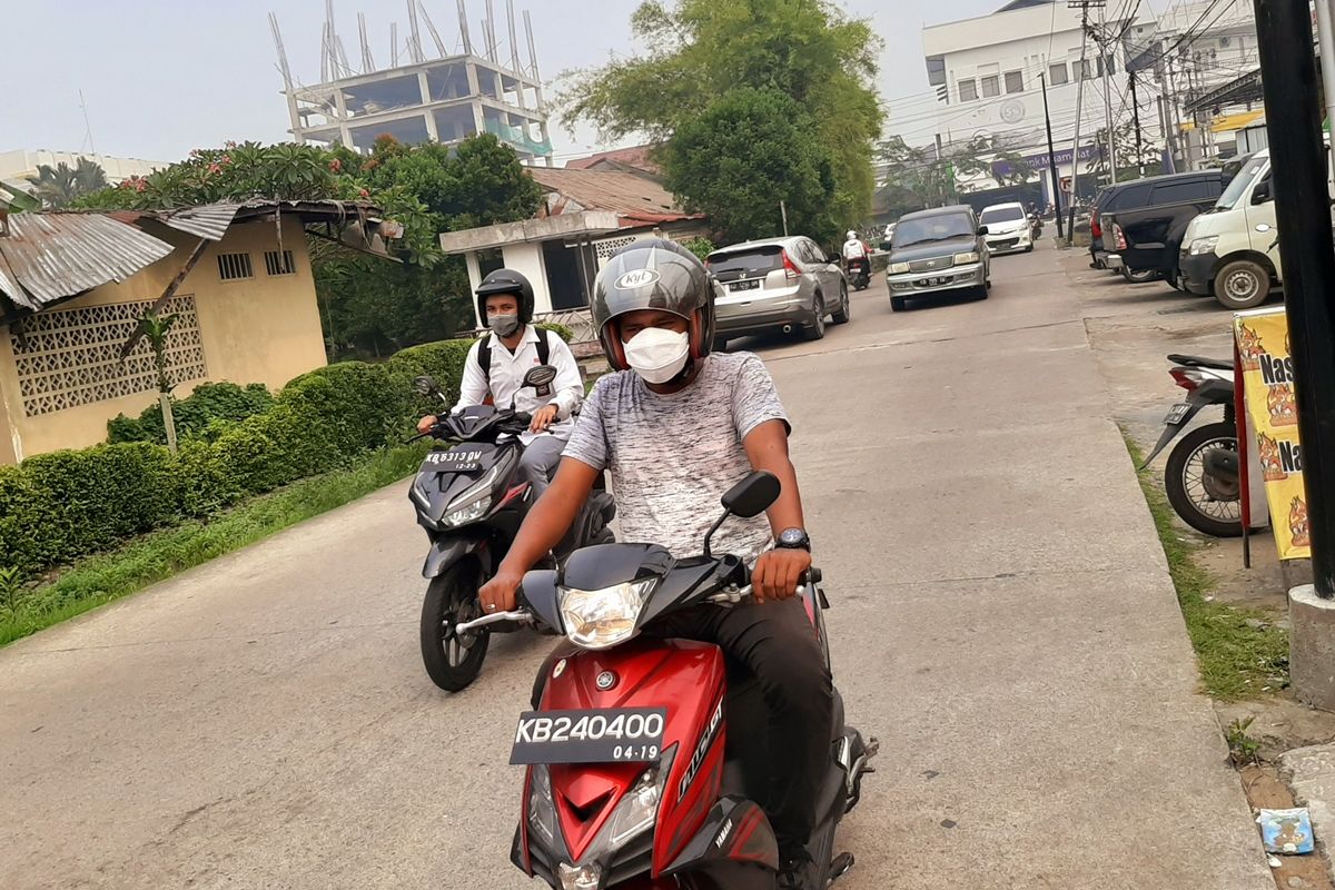 Seorang warga mengenakan masker sewaktu melintas di Jalan Putri Daranante, Kota Pontianak, Kalimantan Barat, Senin (16/9/2019). Berdasarkan data Dinas Kesehatan Kalbar, tercatat 6.026 penderita ISPA sejak terjadinya bencana karhutla.