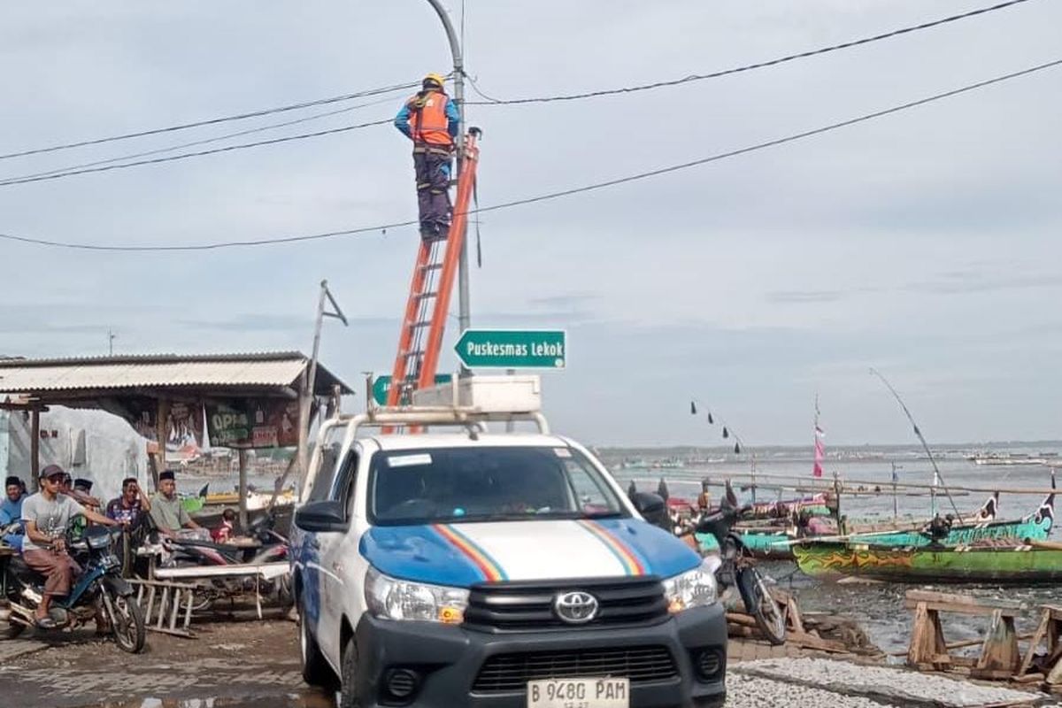 Petugas PLN dari ULP PLN Grati sedang melakukan perbaikan jaringan listrik di kawasan Tempat Pelelangan Ikan (TPI) di Kecamatan Lekok Kabupaten Pasuruan usai tersapu angin puting beliung, Senin (20/01/2025) 