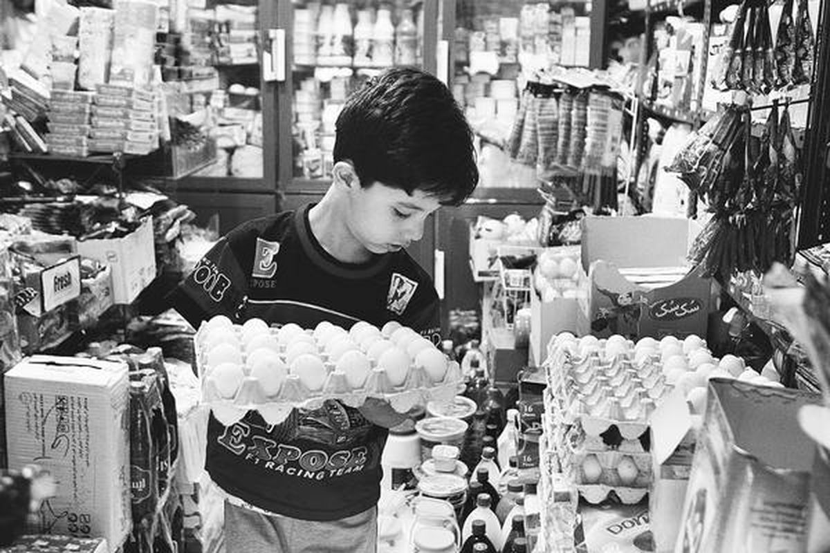 Seorang bocah Iran membeli telur di sebuah toko grosir di Teheran, 30 September lalu. Nilai mata uang riyal Iran anjlok hingga 60 persen sejak akhir tahun lalu, seiring penerapan sanksi ekonomi negara-negara Barat kepada negeri itu. Inflasi terus melambung, dan harga bahan pangan meningkat hingga 50 persen.