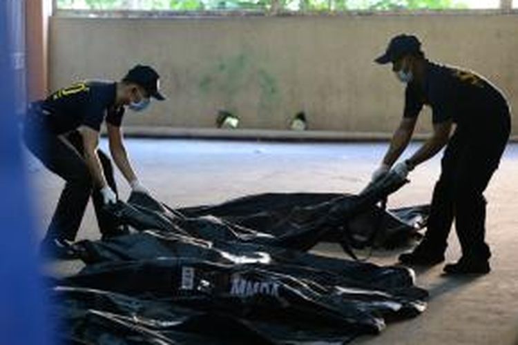 Tim forensik kepolisian Filipina mengangkut korban tewas akibat kebakaran yang menimpa sebuah pabrik sepatu di pinggiran ibu kota Manila, Kamis (14/5/2015).
