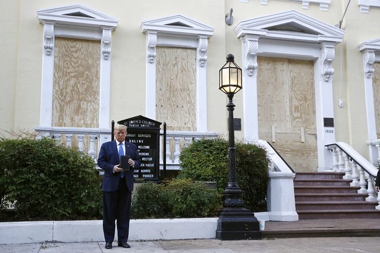 Presiden Donald Trump memegang Alkitab ketika dia mengunjungi bagian luar Gereja St. John di seberang Taman Lafayette dari Gedung Putih pada Senin, 1 Juni 2020, di Washington. Bagian dari gereja terbakar selama protes pada Minggu malam.