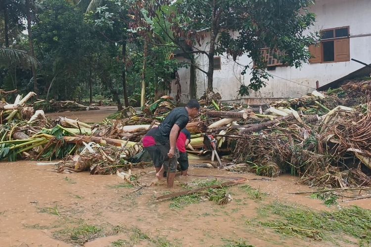 Sejumlah relawan mengevakuasi material sisa banjir yang tersangkut di perkampungan warga Di Desa Sitiarjo, Kecamatan Sumbermanjing Wetan, Kabupaten Malang, Senin (17/10/2022).