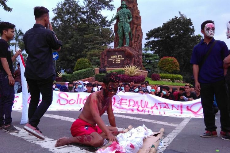 Massa dari Aliansi Kediri saat gelar aksi teatrikal Peduli Kendeng di bawah patung Shodanco Supriyadi, Kota Kediri, Jawa Timur, Minggu (2/4/2017).