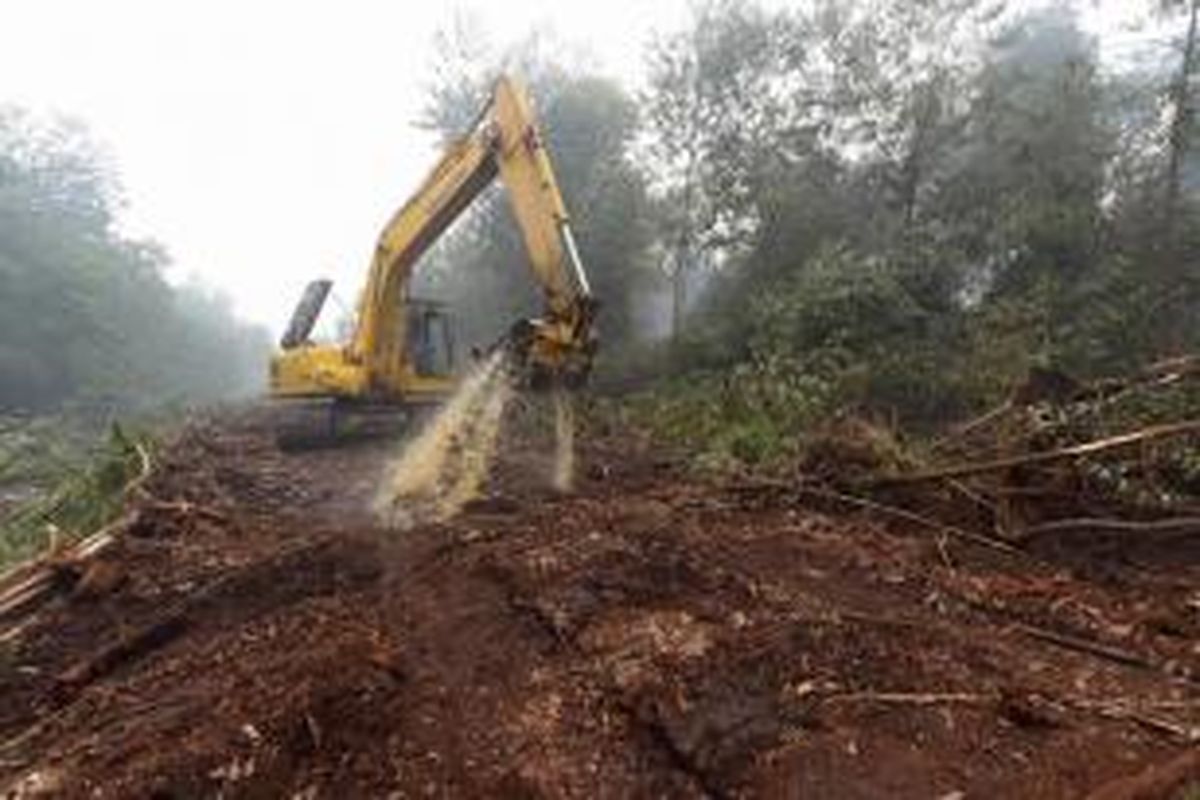 Pekerja Asian Agri menggunakan ekskavator untuk memadamkan api di area konsesi perusahaan di perkebunan kelapa sawit Rantau Baru di Pelalawan, Riau, 16 September 2015.