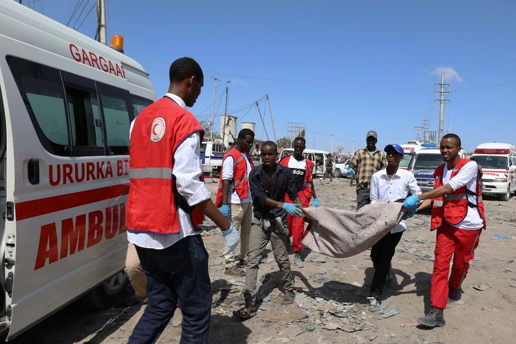 Tim penyelamat dibantu warga sipil mengangkut mayat korban tewas tatkala bom mobil meledak di kawasan sibuk Mogadishu, Somalia, pada 28 Desember 2019. Sebanyak 76 orang tewas dalam serangan tersebut.