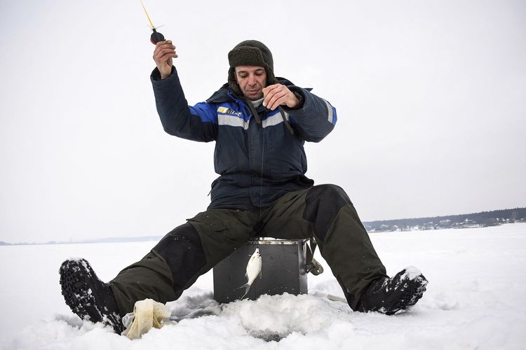 Artyom Ivanov (34) pekerja konstruksi yang tinggal di Maslova Pristan perbatasan Rusia-Ukraina, sedang memancing di sungai es Seversky Donets, Kamis (27/1/2022).