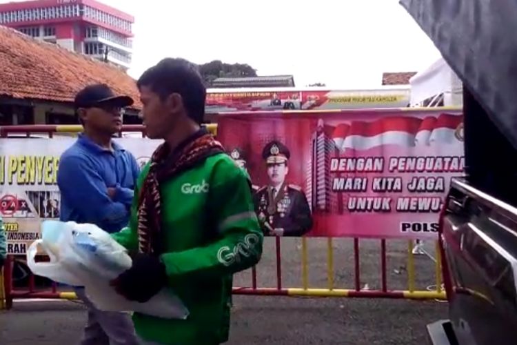Pembagian bantuan beras kemasan 5 kilogram di halaman Polsek Palmerah, Jakarta Barat, Kamis (2/4/2020)