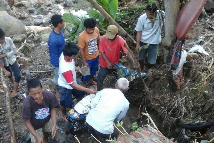 Warga mengevakuasi sepeda motor milik warga Desa Slahung, Kecamatan Slahung, Kabupaten Ponorogo yang hanyut disapu banjir bandang, Jumat ( 17 / 3 / 2017) pagi.