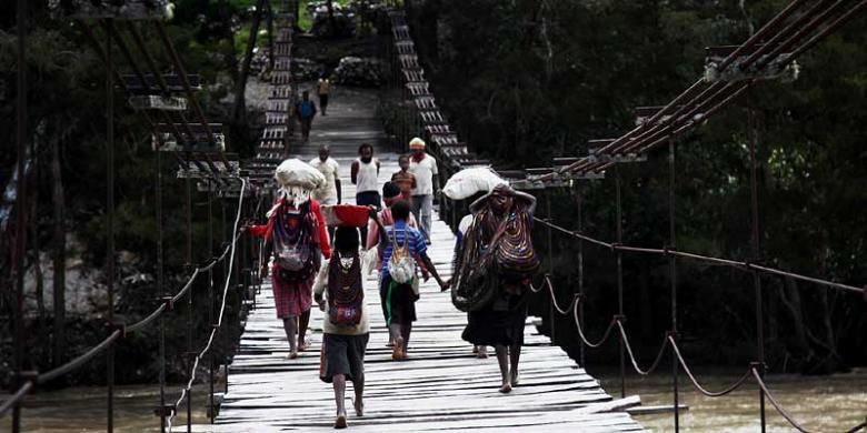 Warga menyeberangi jembatan gantung di Distrik Bolakme, Jayawijaya, Papua, Jumat (6/12/2013). 