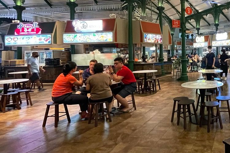 Warga Singapura terlihat menyantap makan malam di Pusat Makanan Lau Pa Sat, Senin (31/01/2022) malam. Singapura mengumumkan pelonggaran peraturan Covid-19, salah satunya penghapusan jaga jarak jika memakai masker mulai 25 Februari 2022.