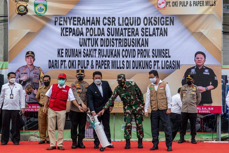 Kuasa Direksi PT OKI Pulp and Paper Mills Gadang Hartawan (kedua kiri) menyerahkan tabung oksigen secara simbosil kepada Kapolda Sumatera Selatan Irjen Pol Eko Indra Heri (ketiga kiri), Gubernur Sumsel Herman Deru (tengah), Komandan Korem 044/Gapo Brigjen TNI Jauhari Agus Suraji (ketiga kanan) disaksikan Perwakilan Manajemen APP Sinar Mas Effendi (kedua kanan) saat penyerahan bantuan CSR Liquid Oksigen dari Asia Pulp and Paper (APP) Sinar Mas untuk Rumah Sakit rujukan Covid-19 di Halaman Polda Sumatera Selatan, Palembang, Senin (12/7/2021).