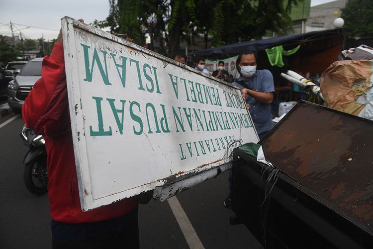 Petugas membongkar atribut-atribut saat melakukan penutupan markas  DPP Front Pembela Islam (FPI) di Petamburan, Jakarta, Rabu (30/12/2020). Polisi dan TNI menutup markas FPI setelah pemerintah memutuskan untuk membubarkan organisasi pimpinan Rizieq Shihab itu.