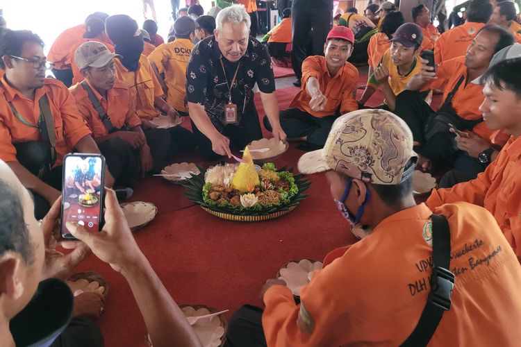 Kepala Dinas Lingkungan Hidup (DLH) Banyumas memotong tumpeng untuk pasukan oranye aaat syukuran adipura di Pendapa Bupati Banyumas, Jawa Tengah, Jumat (3/3/2023).