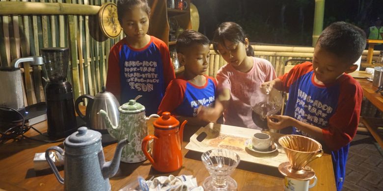 Barista cilik sedang menyajikan kopi di Festival Ngopi Sepuluh Ewu di Desa Kemiren, Banyuwangi, Jatim, Sabtu malam (21/10/2017).