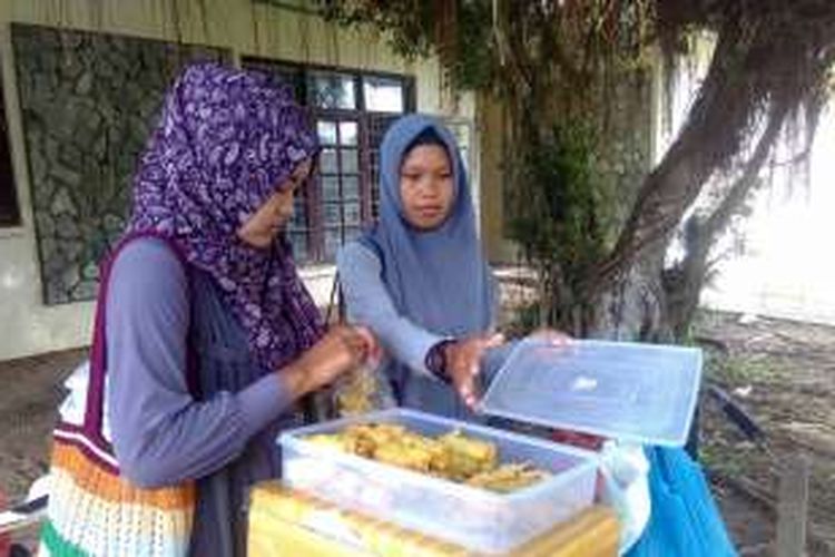Sabariani, melayani pembeli di Kampus Universitas Malikussaleh (Unimal) Kompleks Bukit Indah, Desa Blang Pulo, Kecamatan Muara Satu, Kota Lhokseumawe, Senin (21/11/2016). 