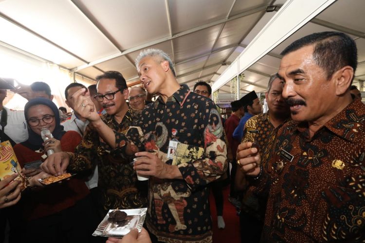 Gubernur Jateng Ganjar Pranowo dan Menteri Koordinator (Menko) Perekonomian Darmin Nasution mencoba roti gaplek saat meluncurkan Kredit Usaha Rakyat (KUR) khusus peternakan rakyat di Desa Kebonagung, Kabupaten Wonogiri, Kamis (6/12/2018). 