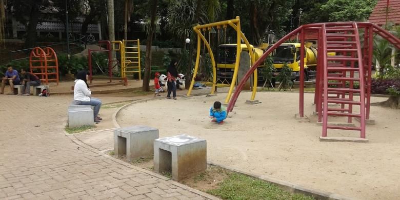 Salah satu warga sedang menemani anaknya bermain di Taman Langsat, Jakarta Selatan, Senin, (23/2/2015).
