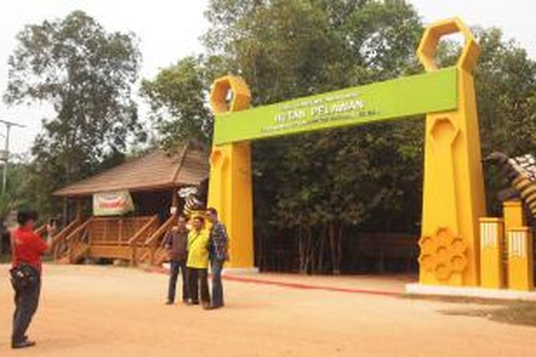 Pengunjung berfoto di pintu masuk Kawasan Hutan Pelawan di Desa Namang, Kabupaten Bangka Tengah