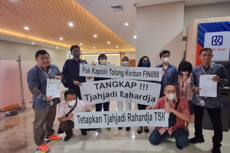 Sejumlah korban membentangkan banner yang meminta Polri menangkap pelaku utama atau dalang robot trading Finn888 di Gedung Bareskrim, Mabes Polri, Jakarta, Rabu (12/4/2023).