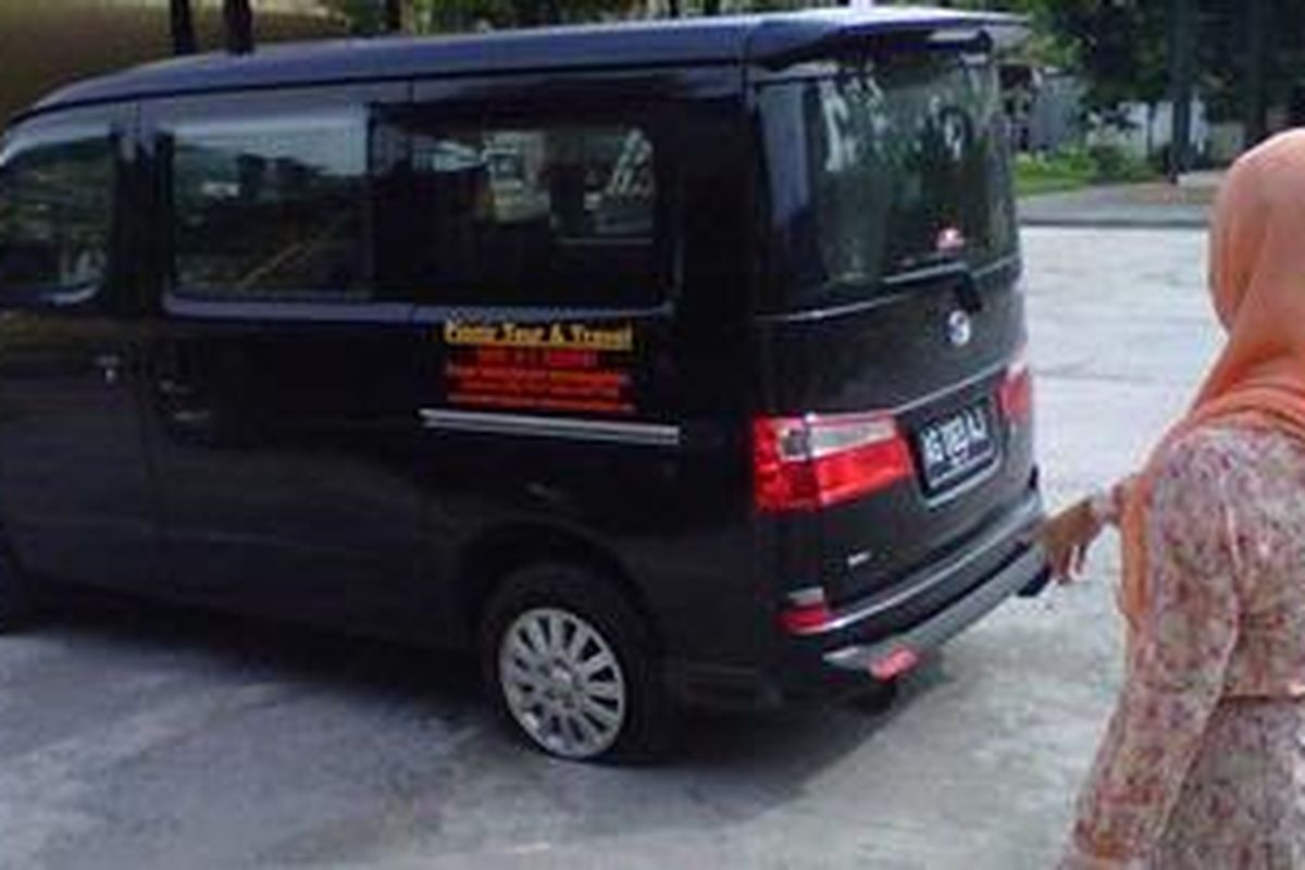 Istri Agus Sudibyo saat menunjukkan mobil yang ditumpanginya bannya kempes, Jum'at (7/11/2012). Selain ban kempes, kaca bagian samping kanan pecah dan uang Rp 148 juta yang disimpan didalam mobil itu hilang. Mobil diamankan di Mapolsek Kediri Kota, Jawa Timur.