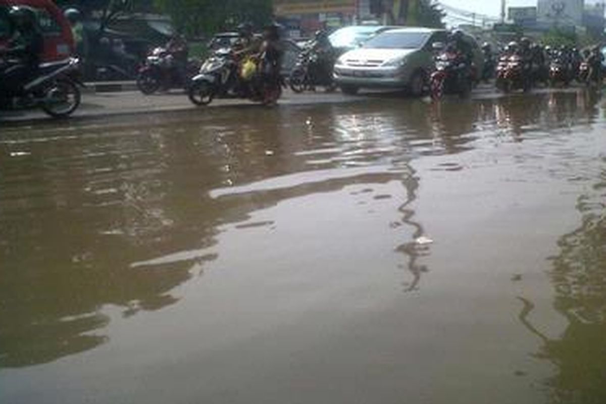 Luapan air dari Kalibaru menggenangi Jalan Raya Bogor yang mengarah ke perempatan Pusat Grosir Cililitan, Jakarta Timur, Senin (8/10/2012). Genangan air membuat kemacetan parah di Jalan Raya Bogor sejak lampu merah Hek. Genangan yang muncul sejak Minggu kemarin itu juga menggenangi sejumlah gang di rumah warga di RT 03 RW 15 Kelurahan Cililitan, Kecamatan Kramatjati, Jakarta Timur. 