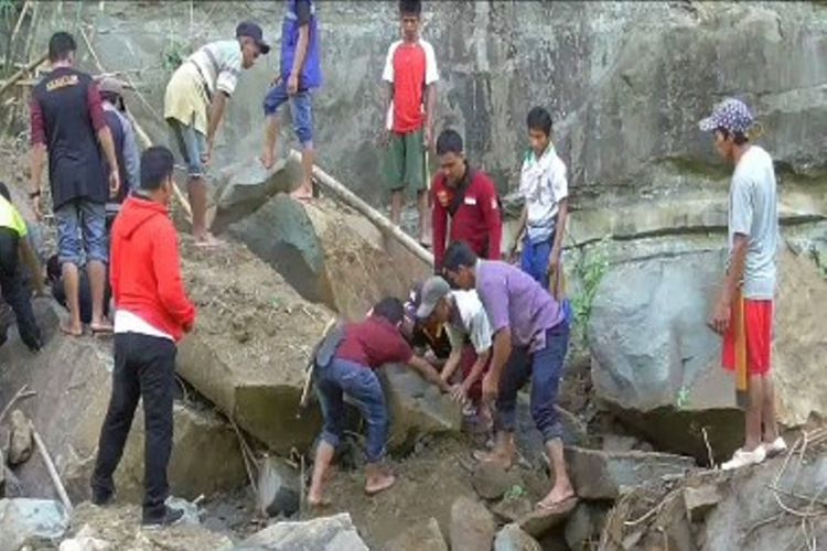 Warga berusaha mengangkat bongkahan batu yang menimpa dua warga Kecamatan Tutar, Polewali Mandar, Sulawesi Barat.