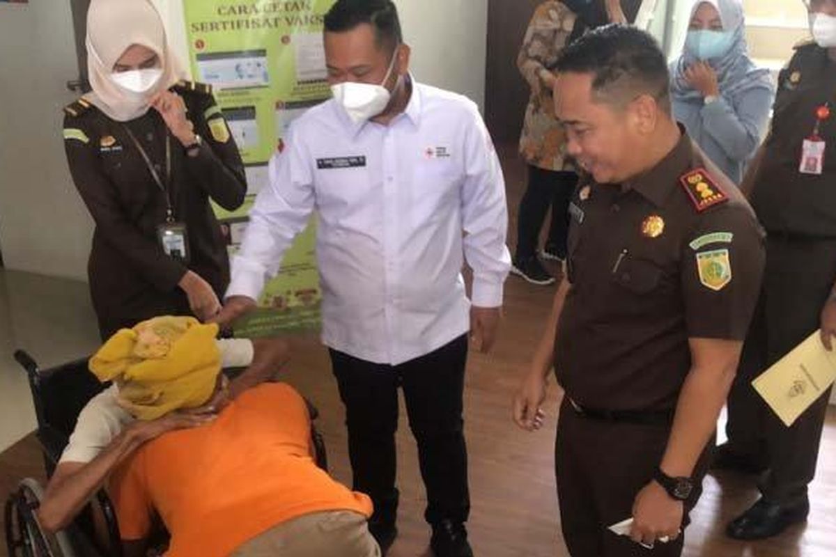 Kajari Gresik, Muhamad Hamdan (kanan) dan Bupati Gresik, Fandi Akhmad Yani (baju putih), menghibur Umar Buang alias Sholikan yang memeluk neneknya, Jumat (4/1/2022). 
