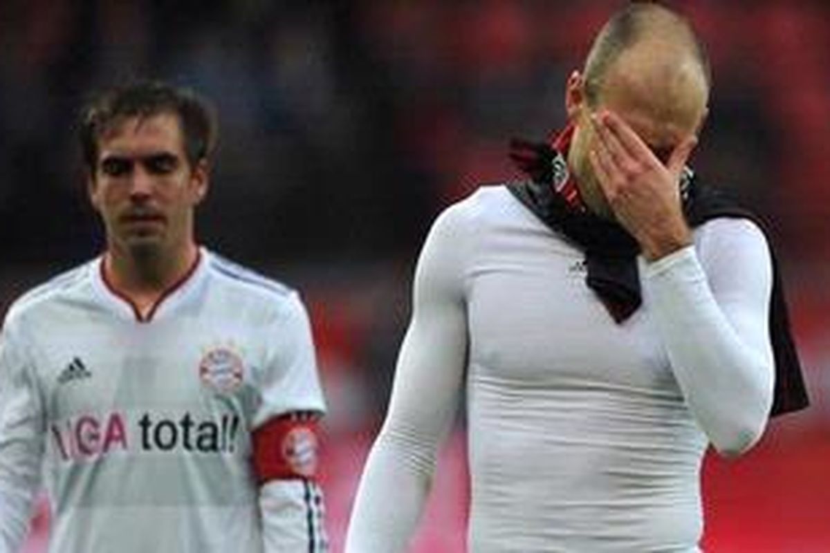Salah satu ekspresi pemain Bayern Muenchen, Arjen Robben (kanan) dan Philipp Lahm (kiri), setelah ditundukkan Bayer Leverkusen 0-2, pada laga Bundesliga, di BayArena, Sabtu (3/3/2012). 