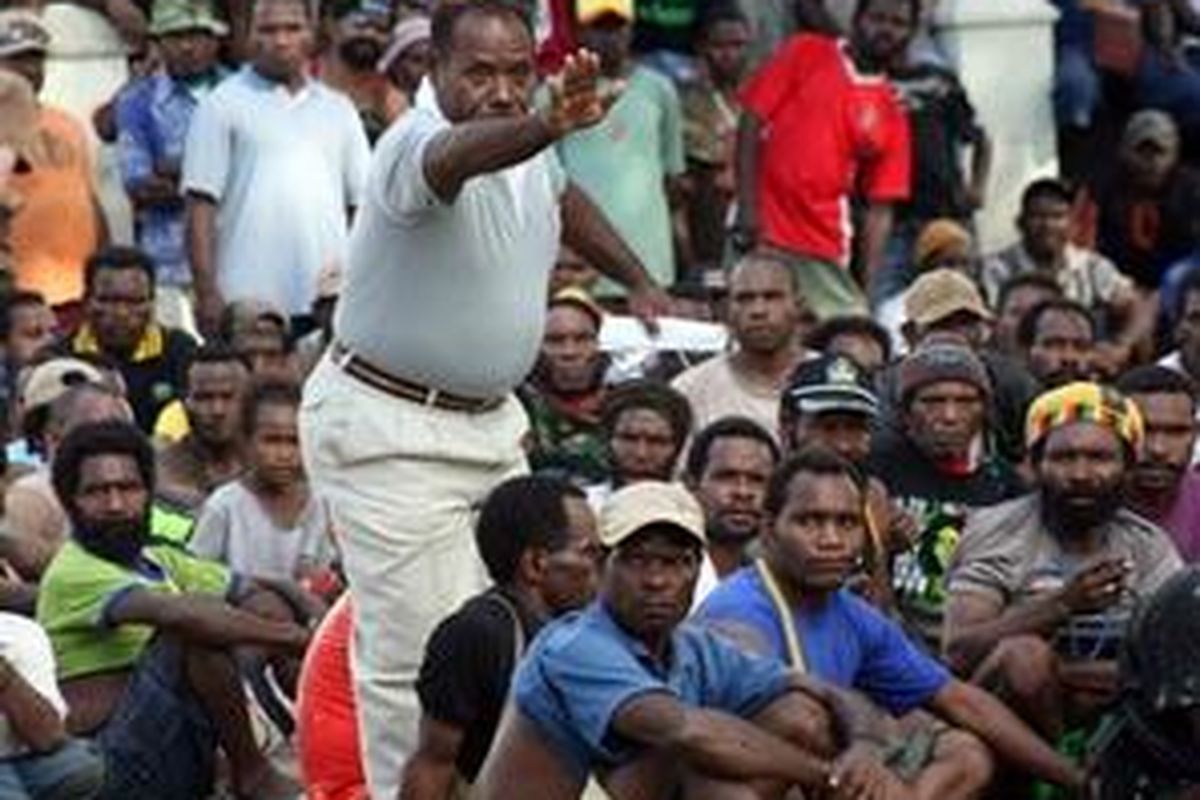 A Papuanese protester gestures toward Indonesian police as they rally in front of the parliament building during a protest in Timika on December 18. Hundreds of supporters of a slain Papuan rebel leader have pelted Indonesian police with stones as tensions flared ahead of the commander's funeral. 
