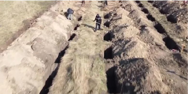 Potongan gambar dari YouTube memperlihatkan pekerja menggali 600 makam di Dnipro, Ukraina. Pemerintah setempat menggunakan cara itu untuk memastikan warganya tetap di rumah selama wabah Covid-19.