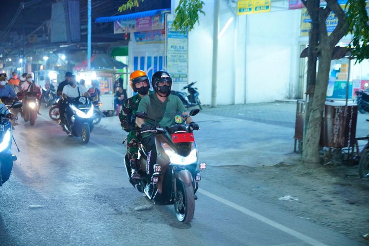 Bobby Nasution membonceng Dandim 02/01 Medan Kolonel Hindratno Devidanto berkeliling mengingatkan warga disiplin menerapkan protokol kesehatan.