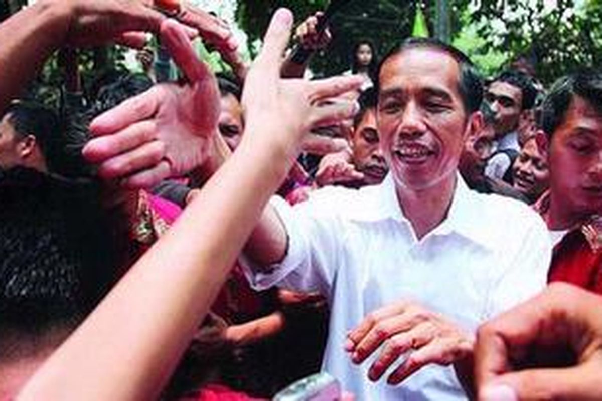 Calon gubernur DKI Jakarta nomor urut 3, Joko Widodo, disambut pendukungnya di sela-sela menyertai keluarga Presiden ke-5 RI, Megawati Soekarnoputri, yang memberikan suaranya dalam Pemilu Kepala Daerah DKI Jakarta di Tempat Pemungutan Suara 31, Kebagusan, Jakarta Selatan, Kamis (20/9/2012).